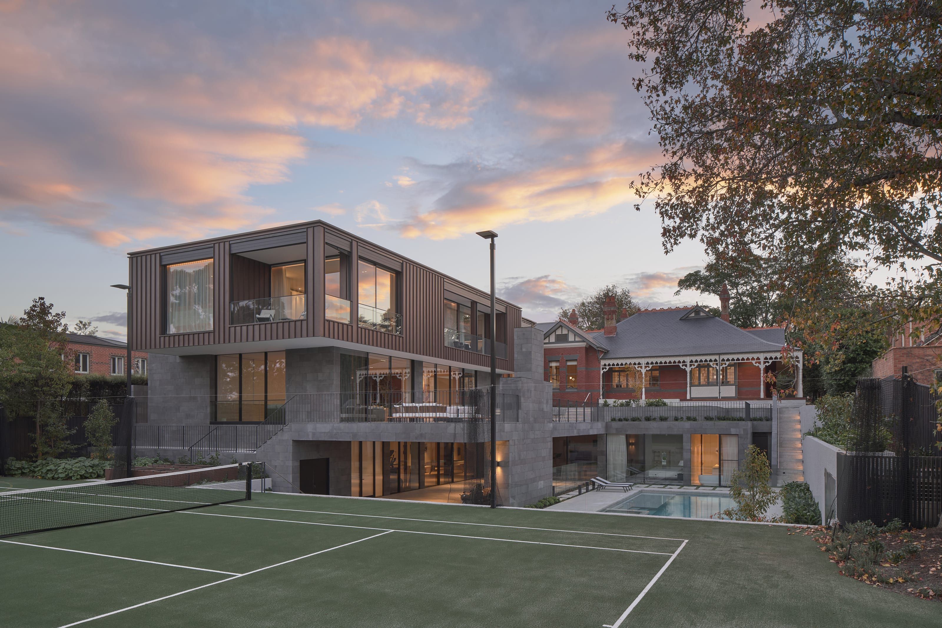 The rear of Cranston House at dusk with the tennis court in the foreground