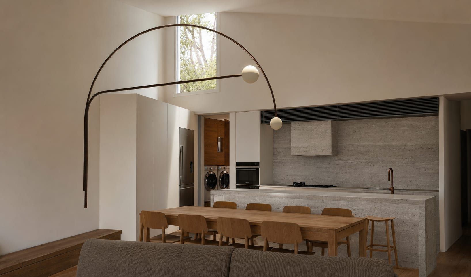 The living, kitchen and dining space in the new addition, under a raked ceiling with a high window